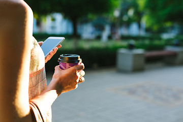 Image showing woman drinking coffee and looking at phone