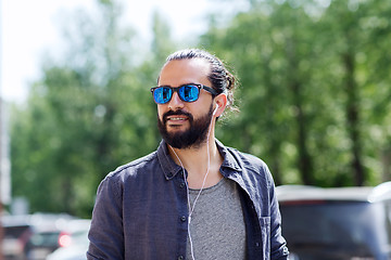 Image showing man with earphones listening to music in city