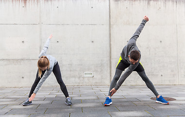 Image showing close up of couple stretching on city street