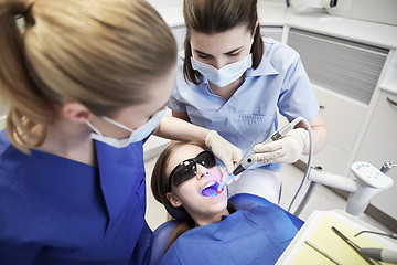 Image showing female dentists treating patient girl teeth