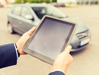 Image showing close up of young man with tablet pc and car