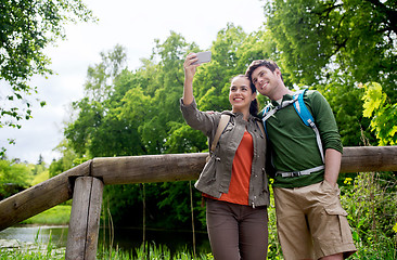 Image showing couple with backpacks taking selfie by smartphone