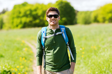 Image showing happy young man with backpack hiking outdoors