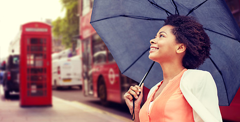 Image showing happy african woman with umbrella in london city