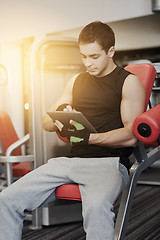 Image showing young man with tablet pc computer in gym
