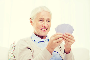 Image showing happy senior woman playing cards at home