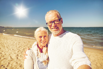 Image showing seniors taking picture with selfie stick on beach