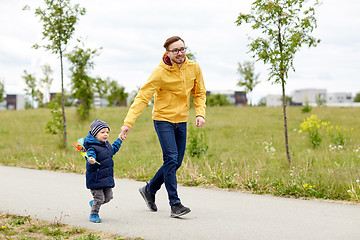 Image showing happy father and son with pinwheel toy outdoors