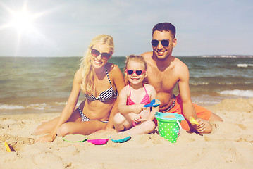 Image showing happy family playing with sand toys on beach