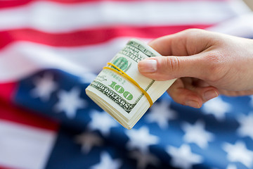 Image showing close up of hand with money over american flag