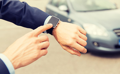 Image showing close up of male hands with wristwatch and car