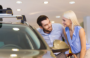 Image showing happy couple buying car in auto show or salon