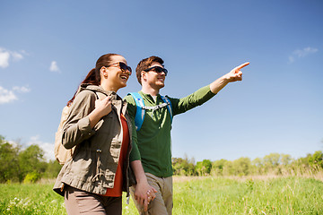 Image showing happy couple with backpacks hiking outdoors