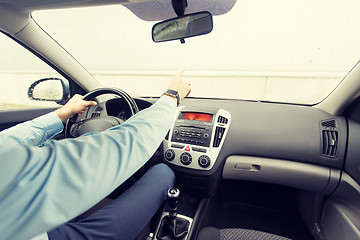 Image showing close up of man driving car and pointing finger