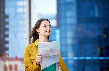 Image showing happy young woman traveling with map in city