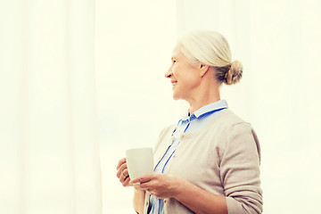 Image showing happy senior woman with cup of tea or coffee