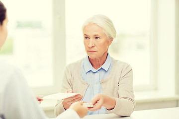 Image showing doctor giving prescription and drug to woman 