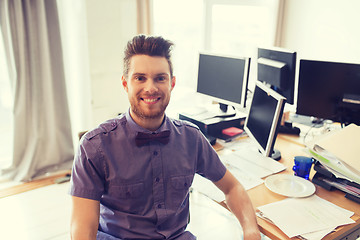 Image showing happy creative male office worker with computers