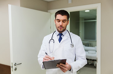 Image showing doctor writing to clipboard at hospital