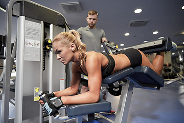 Image showing man and woman flexing muscles on gym machine