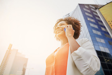 Image showing happy african businesswoman calling on smartphone