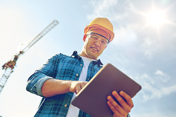 Image showing builder in hardhat with tablet pc at construction