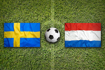 Image showing Sweden vs. Netherlands flags on soccer field