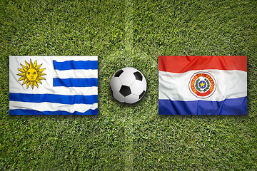 Image showing Uruguay vs. Paraguay flags on soccer field