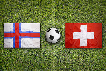 Image showing Faeroe Islands vs. Switzerland flags on soccer field