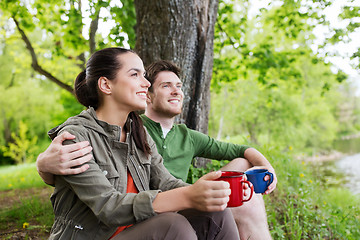 Image showing happy couple with cups drinking in nature