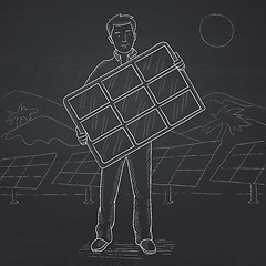 Image showing Man holding solar panel.