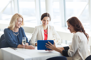 Image showing happy women with tablet pc at restaurant