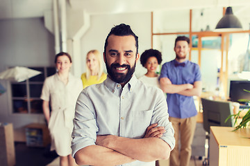 Image showing happy young man over creative team in office