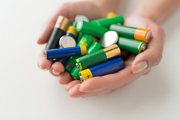 Image showing close up of hands holding alkaline batteries heap