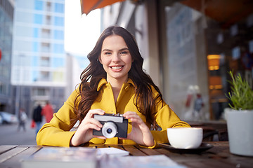 Image showing happy tourist woman with camera at city cafe