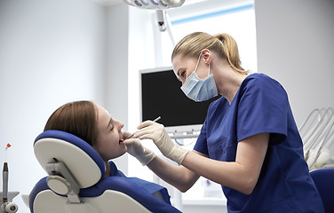 Image showing female dentist checking patient girl teeth