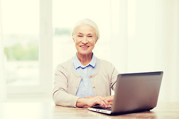 Image showing happy senior woman with laptop at home