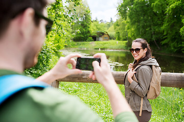 Image showing couple with backpacks taking picture by smartphone