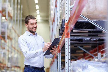 Image showing happy businessman with clipboard at warehouse