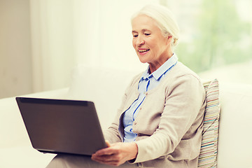 Image showing happy senior woman with laptop at home