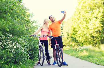 Image showing couple with bicycle taking selfie by smartphone