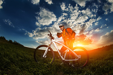 Image showing Man Cyclist with bike on sunset