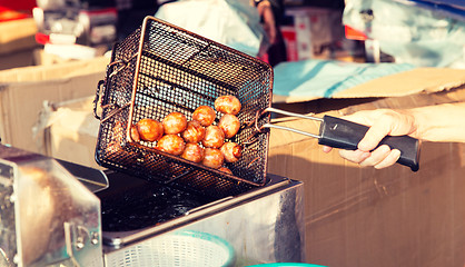 Image showing close up of cook frying meatballs at street market