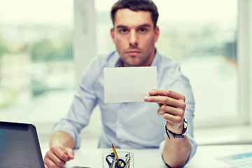 Image showing businessman showing blank paper card at office