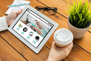 Image showing close up of woman with tablet pc on wooden table