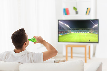 Image showing man watching soccer game on tv and drinking beer