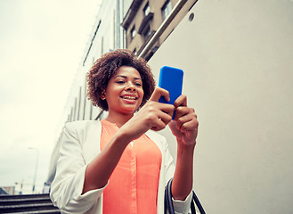 Image showing happy african woman with smartphone in city