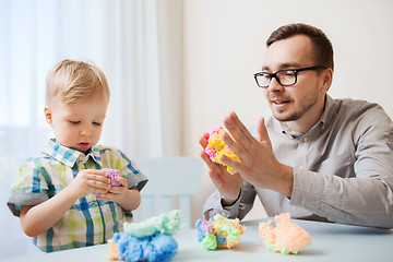 Image showing father and son playing with ball clay at home