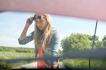 Image showing woman with open hood of broken car at countryside