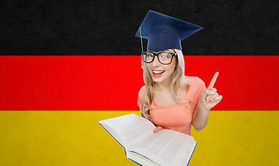 Image showing student woman in mortarboard with encyclopedia